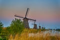 European Travel Destinations. Line of Traditional Romantic Dutch Windmills in Kinderdijk Village in the Netherlands During Golden Royalty Free Stock Photo