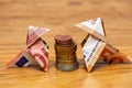 Origami birds made of 10 and 50 euro bank notes around a stack of euro coins