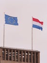 The European Union and the Dutch flags on a building on a gloomy day