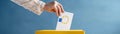 European Union election, hand putting ballot paper into a ballot box on blue background with copy space Royalty Free Stock Photo