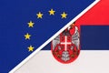 European Union or EU vs Serbia national flag from textile. Symbol of the Council of Europe association