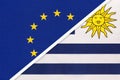 European Union or EU vs Uruguay national flag from textile. Symbol of the Council of Europe association