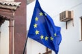 European Union flag blowing in the wind on the street in front of a building Royalty Free Stock Photo