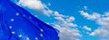 European Union flag fluttering in the wind on a flagpole against a blue sky with clouds on sunny day Royalty Free Stock Photo