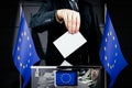European Union flags, hand dropping voting card - election concept Royalty Free Stock Photo
