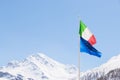 European Union and Italian flag blowing in the wind on the Alps, sunny clear blue sky Royalty Free Stock Photo