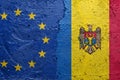 European Union and Moldova - Cracked concrete wall painted with a EU flag on the left and a Moldovan flag on the right stock photo