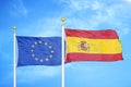 European Union and Spain two flags on flagpoles and blue cloudy sky Royalty Free Stock Photo