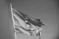 European union twelve star flag torn and with knots in wind on blue sky background. Flag is torn off at side, symbol of