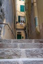 European village narrow ally with stone steps in selective focus and out of focus background building