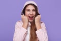 European winsome lady with long hair posing isolated over lilac background, yelling happily, has excited facial expression, keeps Royalty Free Stock Photo