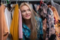 A satisfied blonde creeps shopping in a clothing store.