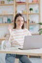 a European woman in her home office is working with a laptop or watching a webinar