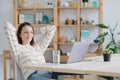 a European woman in her home office is working with a laptop or watching a webinar