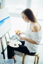 Woman artist painting a picture in a well-lit studio Royalty Free Stock Photo