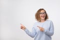 European woman swith smile showing product. Beautiful girl with curly hair pointing to the side Royalty Free Stock Photo