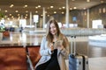 European woman using internet by tablet in airport hall near valise. Royalty Free Stock Photo