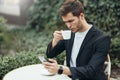 European young and attractive man in casual dress typing messages in social networks.  Business man looks serious, ready to make a Royalty Free Stock Photo