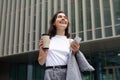 European young business lady happily texting on phone standing outside Royalty Free Stock Photo