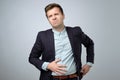 European young man in suit having stomach pain. Colic or flatulence Royalty Free Stock Photo