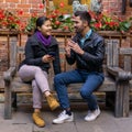 European young man talking to an asian girl holding a smartphone