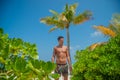 European young tanned handsome sexy man wearing swimming shorts at tropical beach at island luxury resort Royalty Free Stock Photo