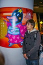 European young tourist standing by the wall of Japanese funny picture.