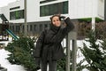 European young woman dressed in winter clothes walks in the yard Royalty Free Stock Photo