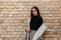 European young woman in a fashionable checkered jacket with white fur in retro style in vintage pants in a T-shirt posing Royalty Free Stock Photo