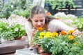 european young woman working with potted flowers in botanical shop