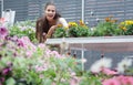 european young woman working with potted flowers in botanical shop