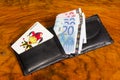 Euros with joker card in wallet, on vintage brown