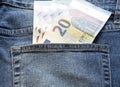 100 euros. Pocket money in blue jeans - five twenty-euro bills in the back pocket of the pants.