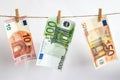 Euros on a rope, euro with a clothespin on a rope isolated on a white background Royalty Free Stock Photo