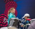 Eurovision Village. Ukraine, Kyiv. 05.12.2017. Editorial. Children with face-art playing drums in front of Board with logo