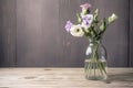 eustoma bloom in glass vase on wooden table