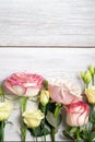 eustoma flowers and pink roses on wooden background in vintage style. Romantic wedding background. View from above