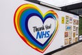 At Euston station, a large poster banner wall with Thank you NHS and rainbow heart.