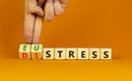 Eustress or distress symbol. Psychologist turns cubes and changes the concept word Eustress to Distress. Beautiful orange table