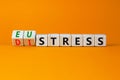 Eustress or distress symbol. Turned wooden cubes and changed the concept word Eustress to Distress. Beautiful orange table orange