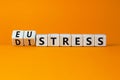 Eustress or distress symbol. Turned wooden cubes and changed the concept word Eustress to Distress. Beautiful orange table orange