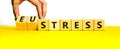 Eustress or stress symbol. Psychologist turns cubes and changes the concept word Eustress to Stress. Beautiful yellow table white