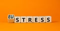 Eustress or stress symbol. Turned the wooden cube and changed the concept word Eustress to Stress. Beautiful orange table orange
