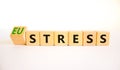 Eustress or stress symbol. Turned the wooden cube and changed the concept word Eustress to Stress. Beautiful white table white