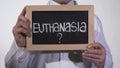 Euthanasia question on blackboard in therapist hands, life or death decision