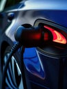 EV Car or Electric car at charging station with the power cable supply plugged in on blurred nature with soft light Royalty Free Stock Photo
