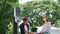 EV car recharging electricity for battery by lovey couple on road trip. Exalt