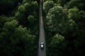 EV car on road going through forest. eco friendly cars. high angle shot.