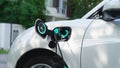 EV charger from home charging station recharging electric car. Peruse