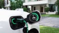 EV charger from home charging station recharging electric car. Peruse